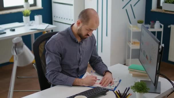 Company employee taking notes on marketing documents — стоковое видео