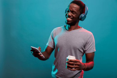 Heyecanlı model akıllı telefondan kulaklıkla çalınan müziği dinliyor.