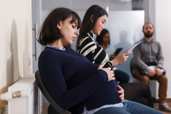 Recrutador de emprego grávida de mãos dadas na barriga esperando no escritório de negócios startup — Fotografia de Stock