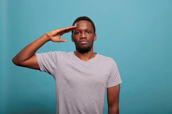 Young man doing military salute with hand over forehead — ストック写真