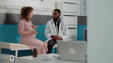 Hasta, tıp kabinesinde doktorla çocuk görüşmesi bekliyor.