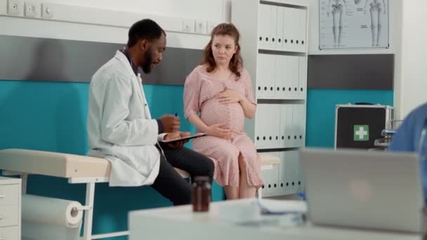 Spécialiste de la santé faisant un bilan de santé consultation avec la patiente enceinte — Video