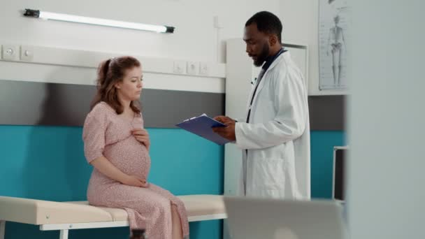 Médico general que consulta el embarazo con la futura madre — Vídeos de Stock