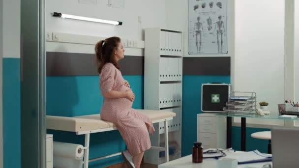 Portret młodej kobiety z brzuchem w gabinecie lekarskim — Wideo stockowe