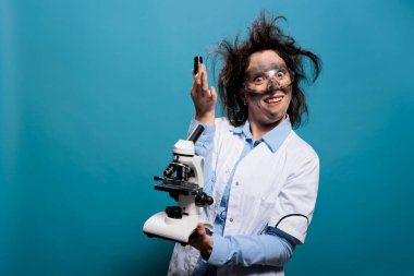 Kirli suratlı, dağınık saçlı, profesyonel mikroskobu olan aptal bilim adamı.