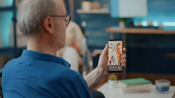 Gepensioneerde man in gesprek met familie op online videoconferentie — Stockfoto