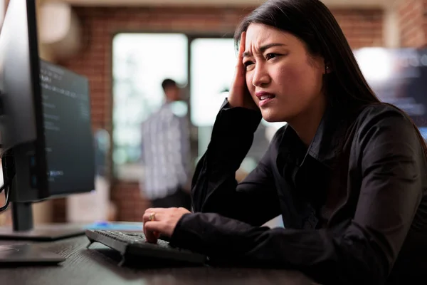 Verward tech engineer zitten aan de computer proberen om netwerk verwerkingsfouten op te lossen. — Stockfoto