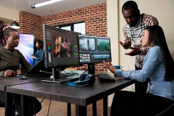 Footage editing specialist using multi monitor workstation to improve frames quality. — Photo