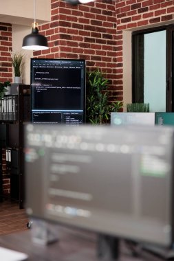 Programlama satırı kodlarını gösteren birden fazla bilgisayar ekranı olan boş veri merkezinin içi.