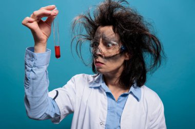 Kirli suratlı, dağınık saçlı, kırmızı sıvı madde örneğiyle dolu şişede kaşlarını çatan sinirli kimyager..