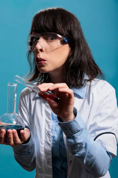 Especialista en bioquímica que tiene tarros de vidrio de química profesional mientras mezcla cuidadosamente compuestos desconocidos. —  Fotos de Stock