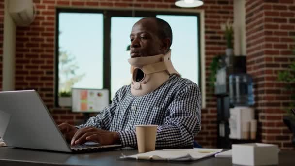 Office worker in pain working with medical neck foam at desk — Vídeos de Stock