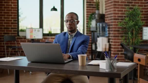 Πορτρέτο του επιχειρηματία που χρησιμοποιεί φορητό υπολογιστή για να περιηγηθείτε στο διαδίκτυο στο γραφείο εκκίνησης — Αρχείο Βίντεο