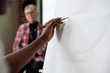 Tuvale vazo çizimi yapan yaratıcı öğrenciye yakın çekim