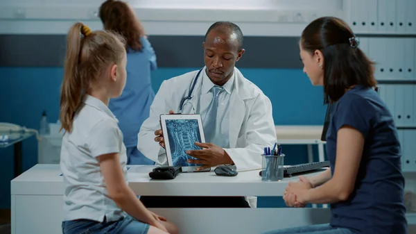 Allmän läkare som visar röntgendiagnos på tabletten — Stockfoto