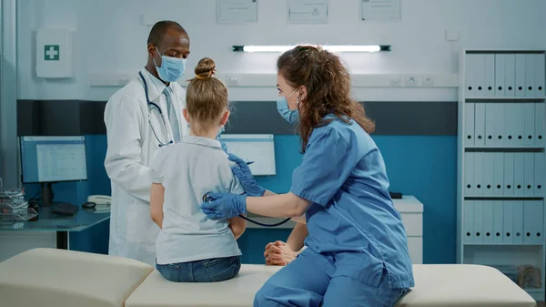 Läkarassistent konsultera barn med stetoskop i skåp — Stockfoto