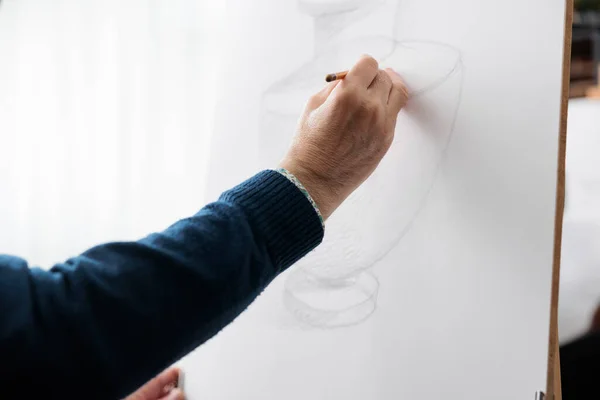 Close up of senior teacher drawing vase model on white canvas — стоковое фото