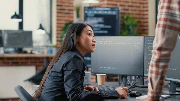 Database developer pointing pencil at computer screen with software compiling code explaining source algorithm to coworker — Stock Photo, Image