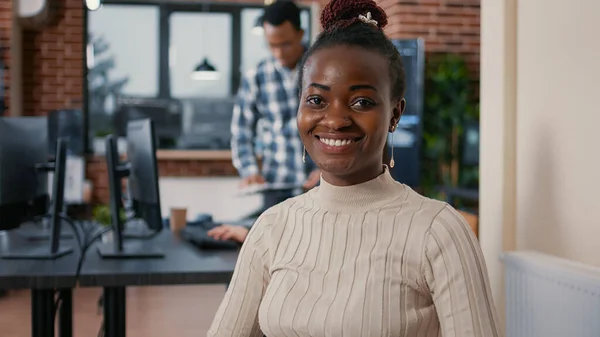 Portrait of african american programer sitting down coding on laptop looking up and smiling — Stock Photo, Image