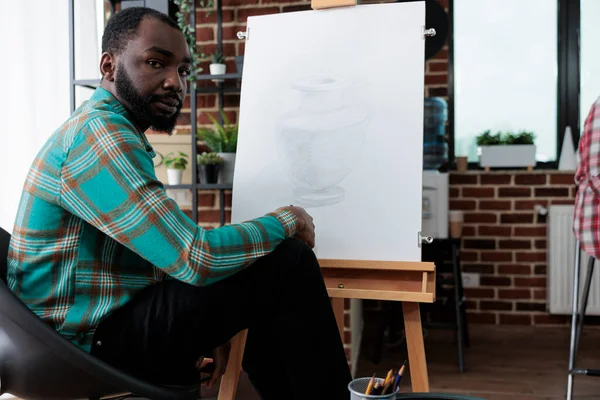 Retrato de estudante sorrindo sentado na frente de tela branca desenho esboço — Fotografia de Stock