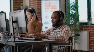 Erkek operatör çağrı merkezinde müşterilerle konuşuyor.