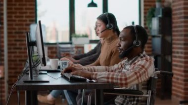 Afrikalı Amerikalı çalışan müşterilerle konuşmak için kulaklık kullanıyor.
