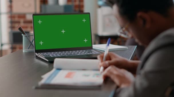 Man using greenscreen on laptop and taking notes — Vídeos de Stock