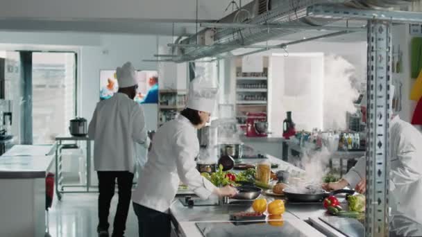 Жіночий шеф-кухар готує органічні овочі на сковороді на плиті — стокове відео
