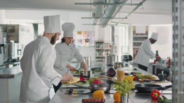 İtalyan yemeği pişirmek için tabakta parmesan peyniri rendeleyen erkek şef.