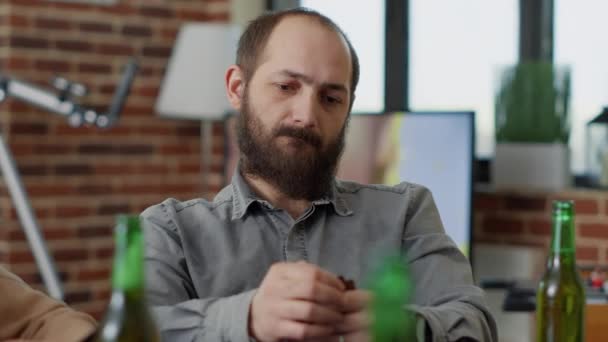 Portrait d'homme caucasien buvant de la bière et jouant au jeu de cartes — Video