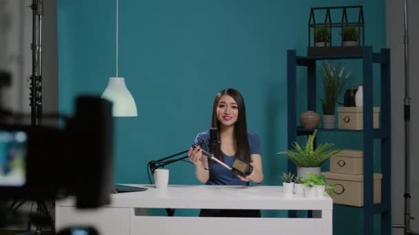 Asian influencer holding tripod head product on live podcast — Vídeos de Stock
