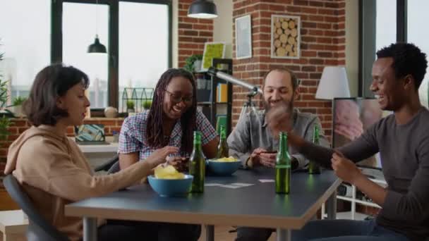 Grupo feliz de pessoas desfrutando de estratégia de tabuleiro com cartões — Vídeo de Stock