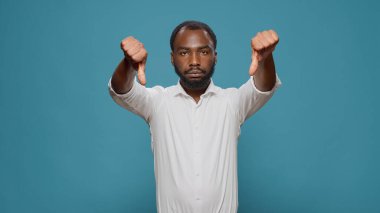 Mutsuz adam baş parmağını kaldırıyor.