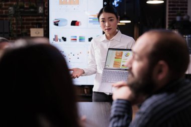 Çeşitli takımlarla satış istatistikleri hakkında konuşan pazarlama müdürünün seçici odak noktası