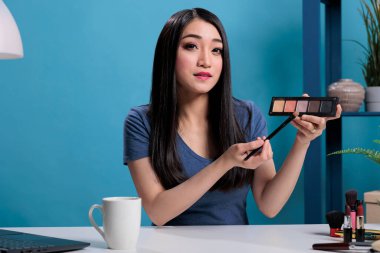 Kozmetik paleti inceleyen yaratıcı içerik yaratıcısının portresi