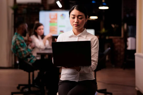 Porträtt av asiatisk kvinna som håller laptop i start kontor under sen kväll möte — Stockfoto