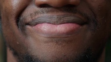 Makro erkek modelin kamera karşısında samimi bir gülümseme görüntüsü.