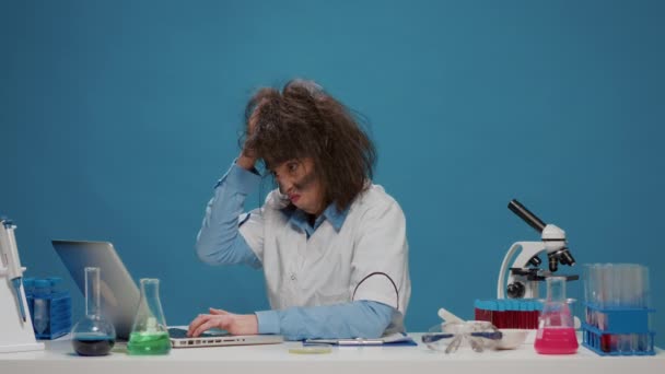 Amusante gekke wetenschapper werkt aan laptop en gedraagt zich gek — Stockvideo