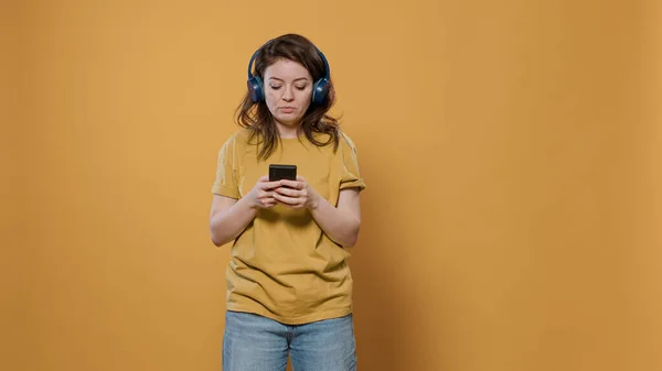 Portrait of relaxing woman using smartphone listening to music on wireless headphones starting to dance — Foto de Stock