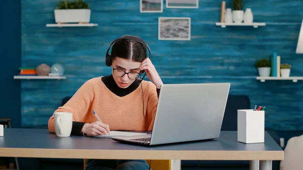 Vrouw met koptelefoon aan het praten op online videogesprek — Stockfoto