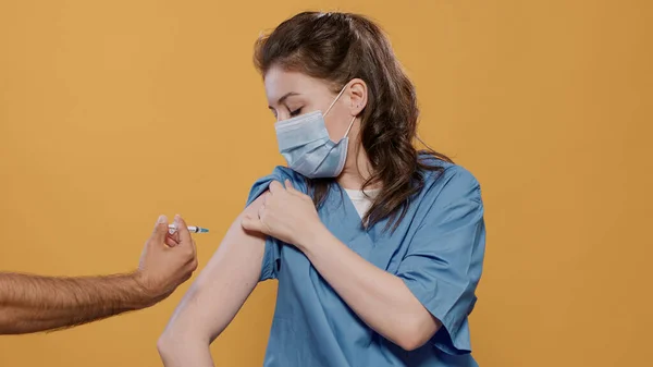 외과용 마스크를 착용 한 의사가 소매를 착용하고 상습적 인 협조나 독감 백신을 사용 한 모습 — 스톡 사진