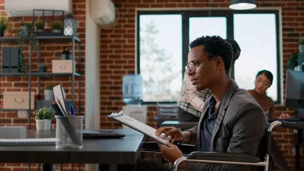 Belgelerdeki mali tablolara bakan erkek çalışan.