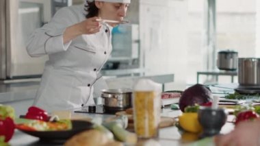 Kadın aşçı gurme çorbası tarifi pişiriyor ve lezzet testi yapıyor.