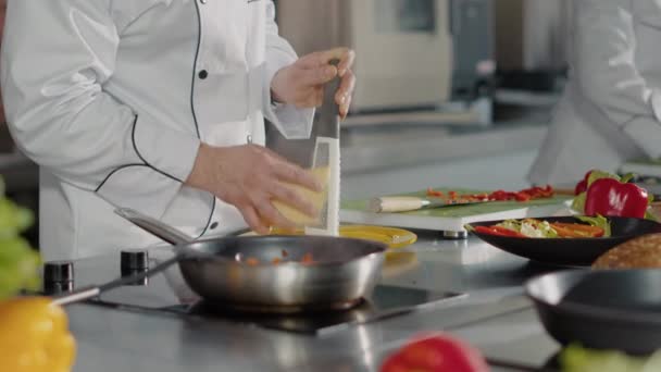 Professionele chef-kok met rasp om versnipperde kaas op schotel toe te voegen — Stockvideo