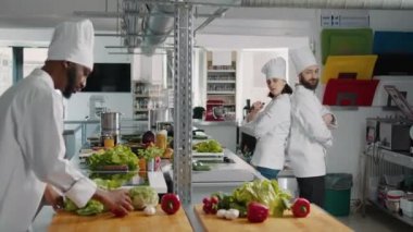 Profesyonel şeflerden oluşan bir ekip bıçaklarla komik hareketler yapıyor.