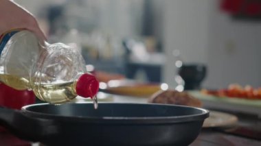 Profesyonel aşçı kızartma tavasına organik zeytinyağı ekliyor.