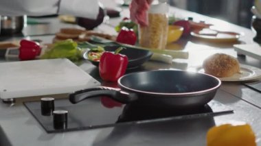 Erkek şef kızartma tavasında pişirmek için zeytinyağlı et koyuyor.