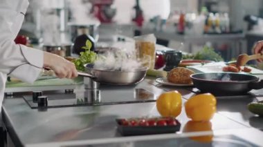 Profesyonel aşçı kızartma tavasında gastronomi yemeği hazırlıyor.