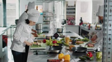 Kadın şef sarımsak kesmek için bıçak kullanıyor.