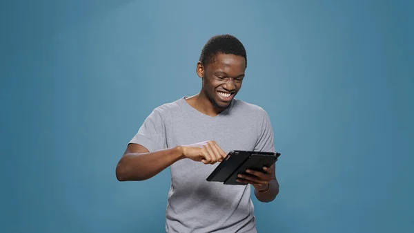 Joven adulto riéndose de aplicación de medios sociales en tableta digital —  Fotos de Stock